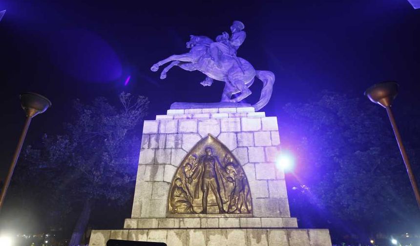 ZAFER SİMGESİ
Bu oturuşta bir korkusuzluk ve Türklüğün gücü ifade ediliyor. Sert çelik bir kol kılıca uzanmış. Kaidenin yanlarında iki kabartma ve öteki yanlarında da yazılar var. Kabartmanın birinde, iskelede sandalın yanında mermi ve cephane taşıyan insanlar görülmekte. Arkalarında, bir de top arabasının bulunması, savaş anını canlandırdığını gösterir.